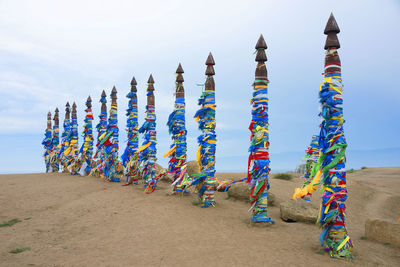 Multi colored umbrellas on sand at beach against sky