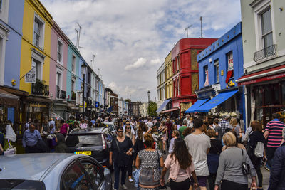 Crowd amidst buildings on street in city