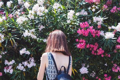 Rear view of woman standing by flowers