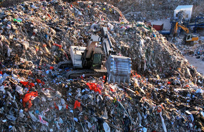 Landfill with construction and demolition waste .  excavator working on industrial landfill. 