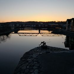 Scenic view of river against clear sky during sunset