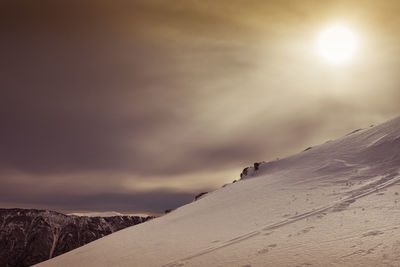 Snow covered mountain against sky during sunset