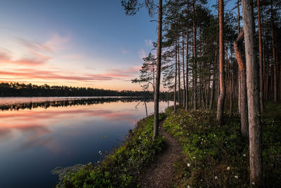 Scenic view of calm lake against sky at sunset