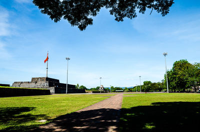 Scenic view of park against cloudy sky