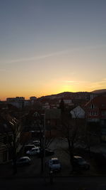 Cars on city against sky during sunset