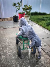 Rear view of girl sitting on footpath