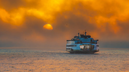 Scenic view of ferry against sky during sunrise