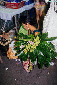 Midsection of woman in basket for sale at market