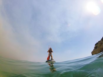 Man standing in sea against sky