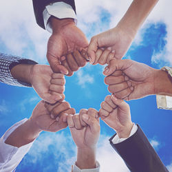 Low angle view of people gesturing against sky