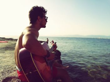 Man playing guitar at seaside