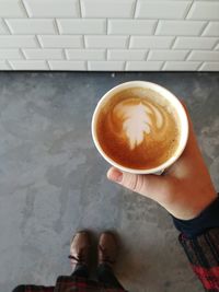 Low section of woman holding coffee cup on table