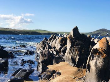 Rocks on beach against sky