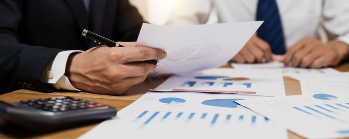 Midsection of business colleagues working on table