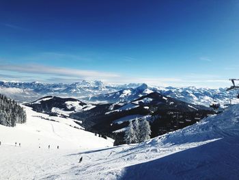 Scenic view of snow covered mountains against blue sky