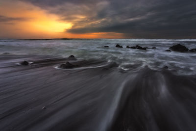 Scenic view of beach against sky during sunset