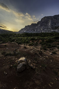 Rock formation on land against sky during sunset