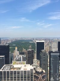 Cityscape by central park against sky