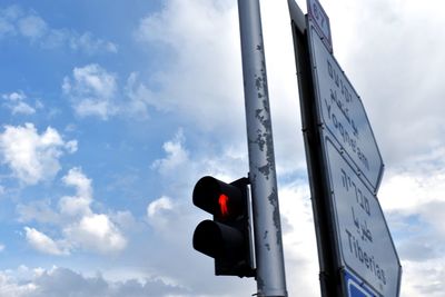 Low angle view of road signal against sky