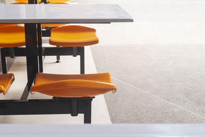 Dining table with orange seat in food center with copy space text