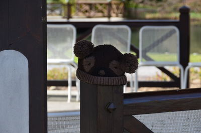 Stuffed toy on railing by window