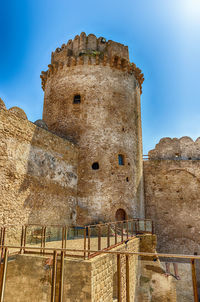 Low angle view of old ruin building against blue sky