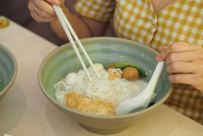 Close-up of hand holding bowl of food