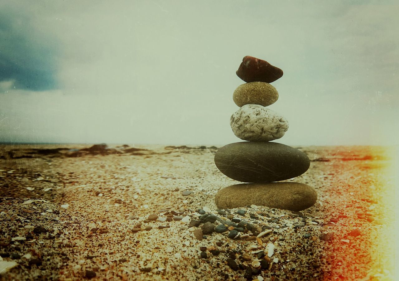 beach, sea, sky, horizon over water, pebble, tranquility, shore, tranquil scene, stack, stone - object, nature, scenics, sand, beauty in nature, balance, rock - object, water, large group of objects, idyllic, cloud - sky