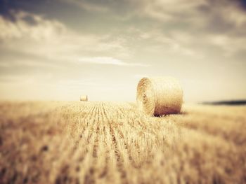 Scenic view of field against cloudy sky