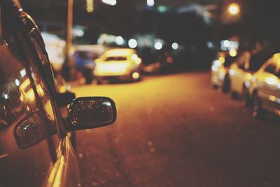 Close-up of illuminated cars on street at night