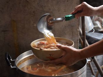 Cropped hands of person serving food in kitchen