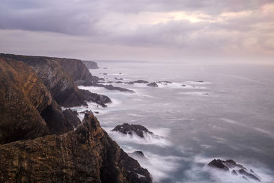 Scenic view of rocks in sea against sky