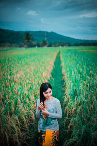 Young man using mobile phone in field