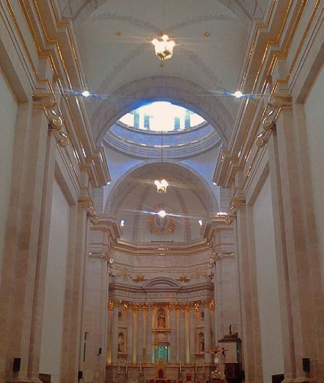 indoors, architecture, church, ceiling, low angle view, place of worship, religion, arch, built structure, spirituality, lighting equipment, chandelier, hanging, cathedral, illuminated, ornate, window, interior