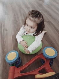 High angle view of cute girl sitting on table