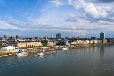 Scenic view of river by buildings against sky