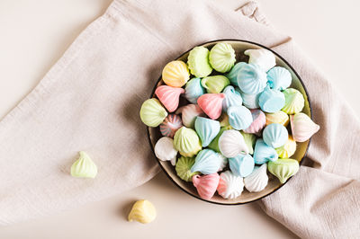 Close up of multi-colored mini meringues on a plate on the table top view