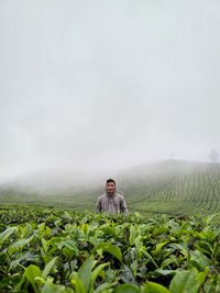 Man standing in field against sky