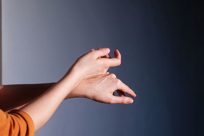 Hands of a young woman gently rub with a cream from dryness and moisturize and nourish the skin