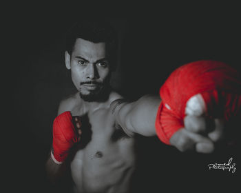 Portrait of young man against black background