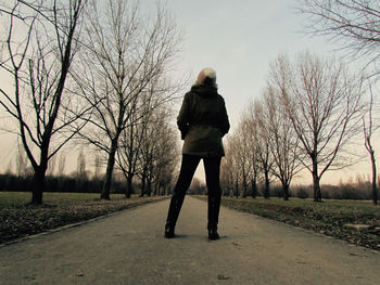 Full length rear view of man walking on field