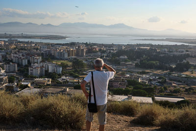 Rear view of woman looking at city buildings against sky