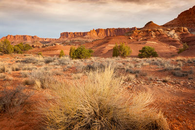 Rock formations on landscape against cloudy sky