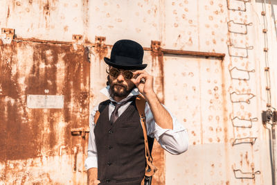 Full length of man photographing against wall