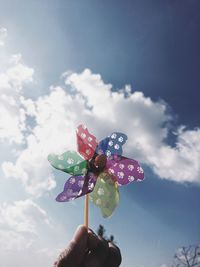 Low angle view of person holding umbrella against sky