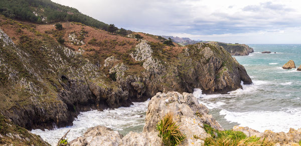 Scenic view of rocky beach against sky