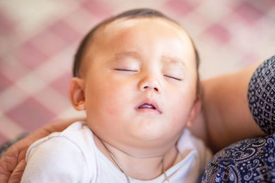 Portrait of cute baby lying on bed