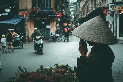 Rear view of people riding motorcycle on road