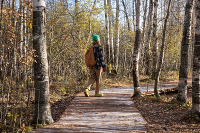 Rear view of woman walking in forest