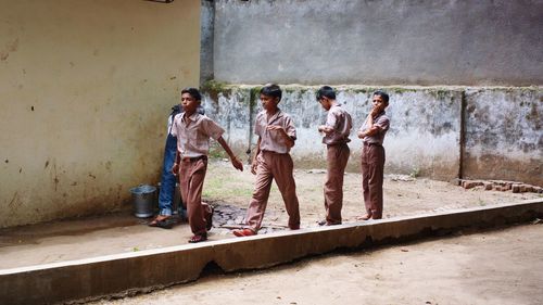 Side view of people standing against wall